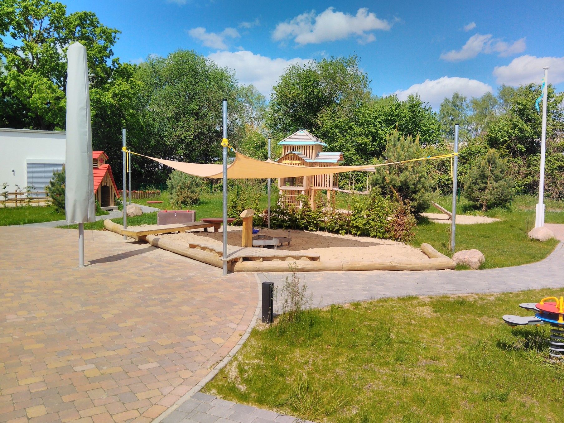 Moderner kleiner Spielplatz mit Sonnenschutz
